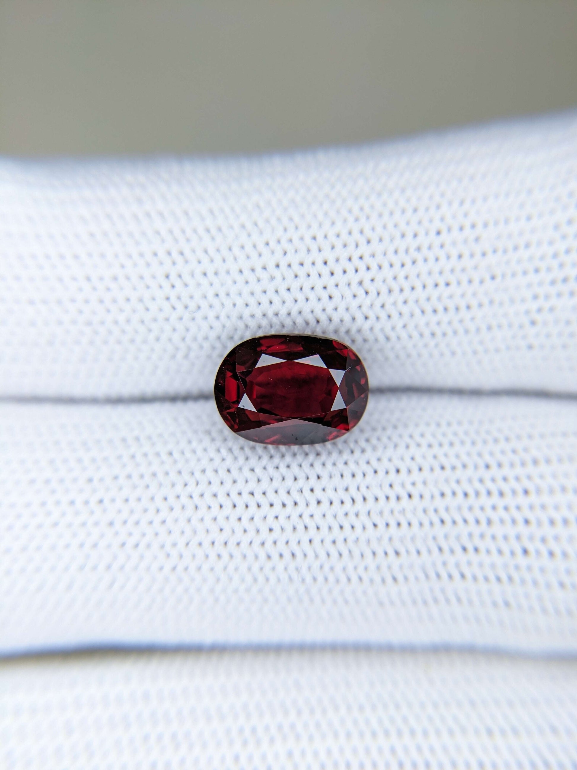 Red ruby gemstone on a white fabric background