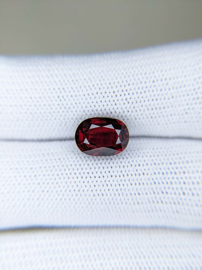 Red ruby gemstone on a white fabric background