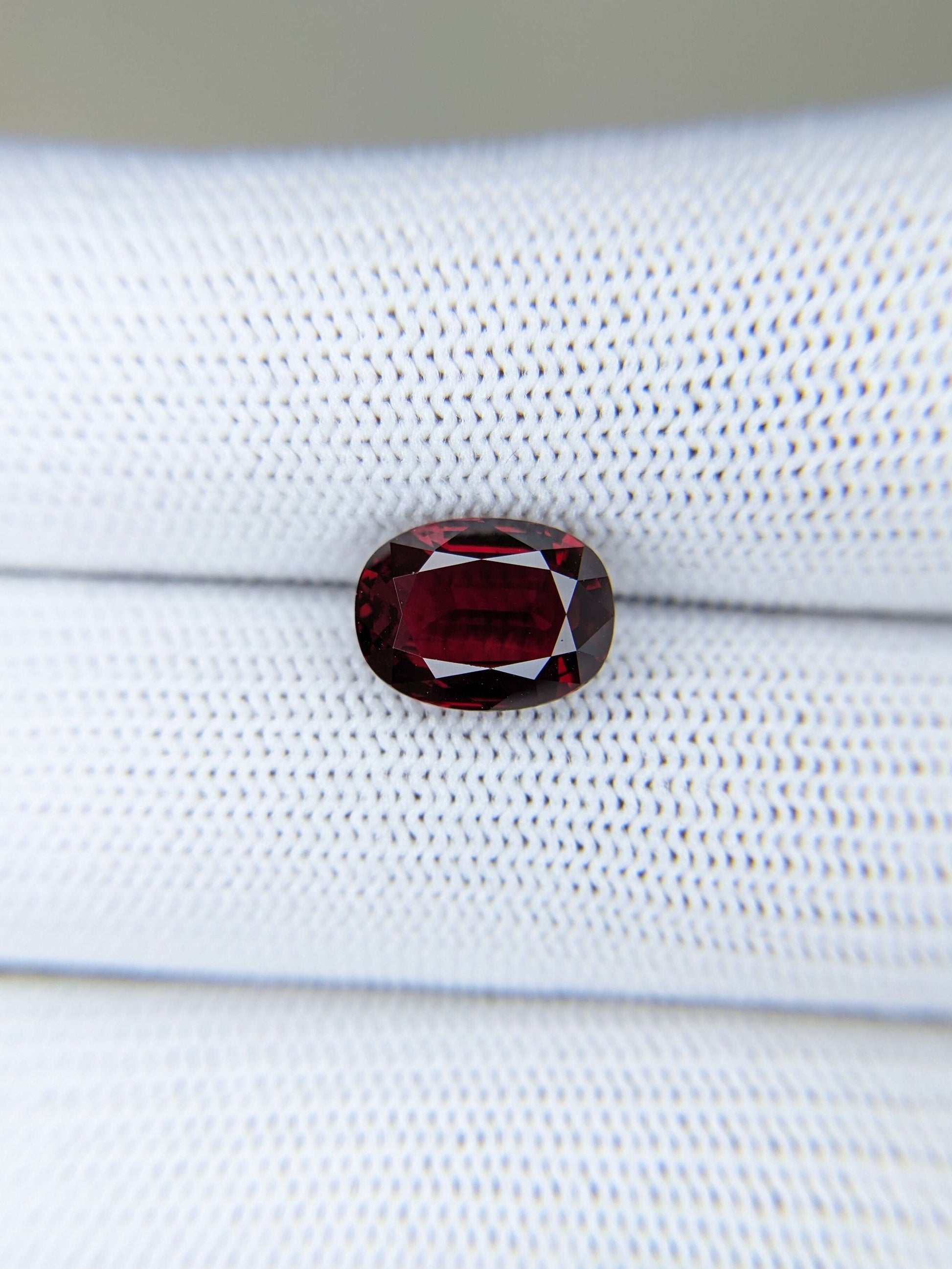 Red ruby gemstone on a white fabric background