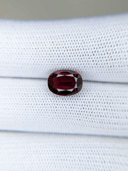 Red ruby gemstone on a white fabric background