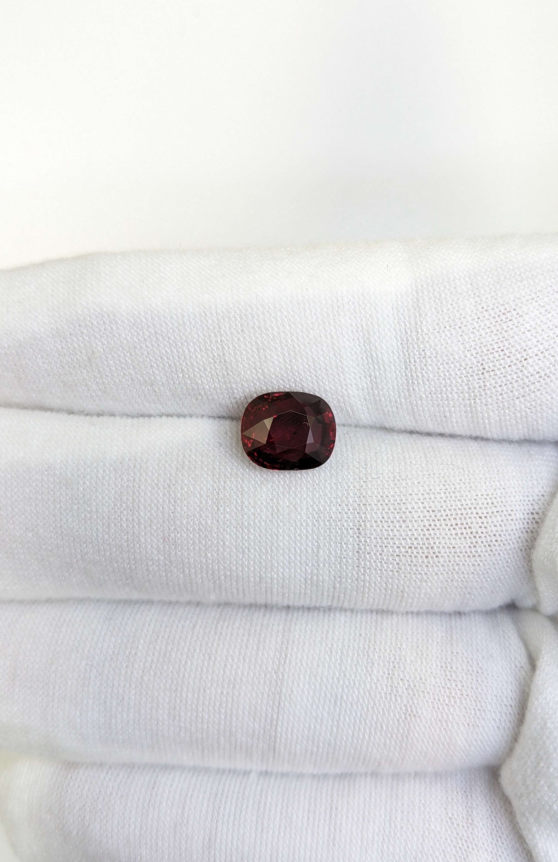 Red ruby gemstone on a white cloth background
