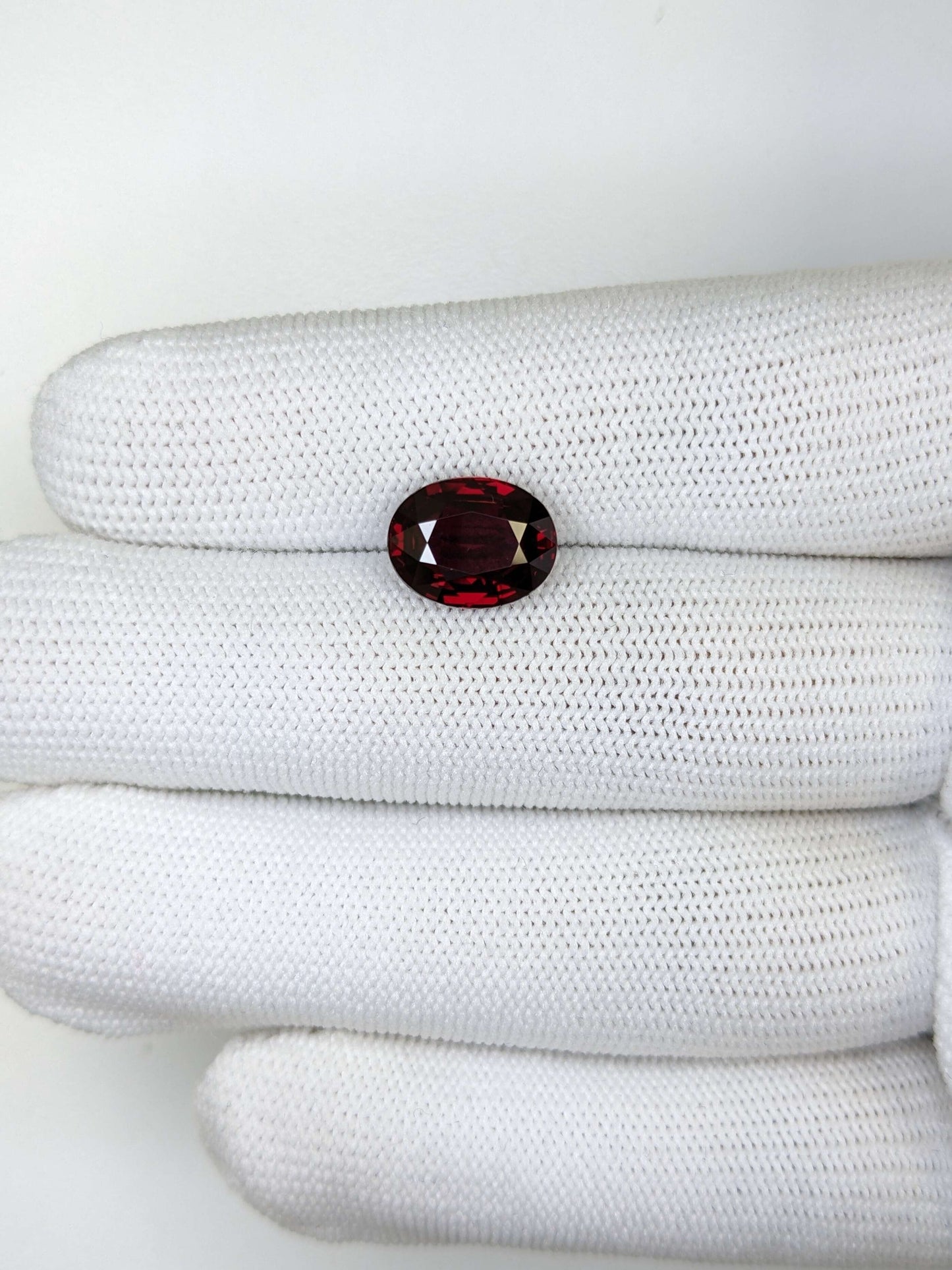 Red ruby gemstone on a white fabric surface