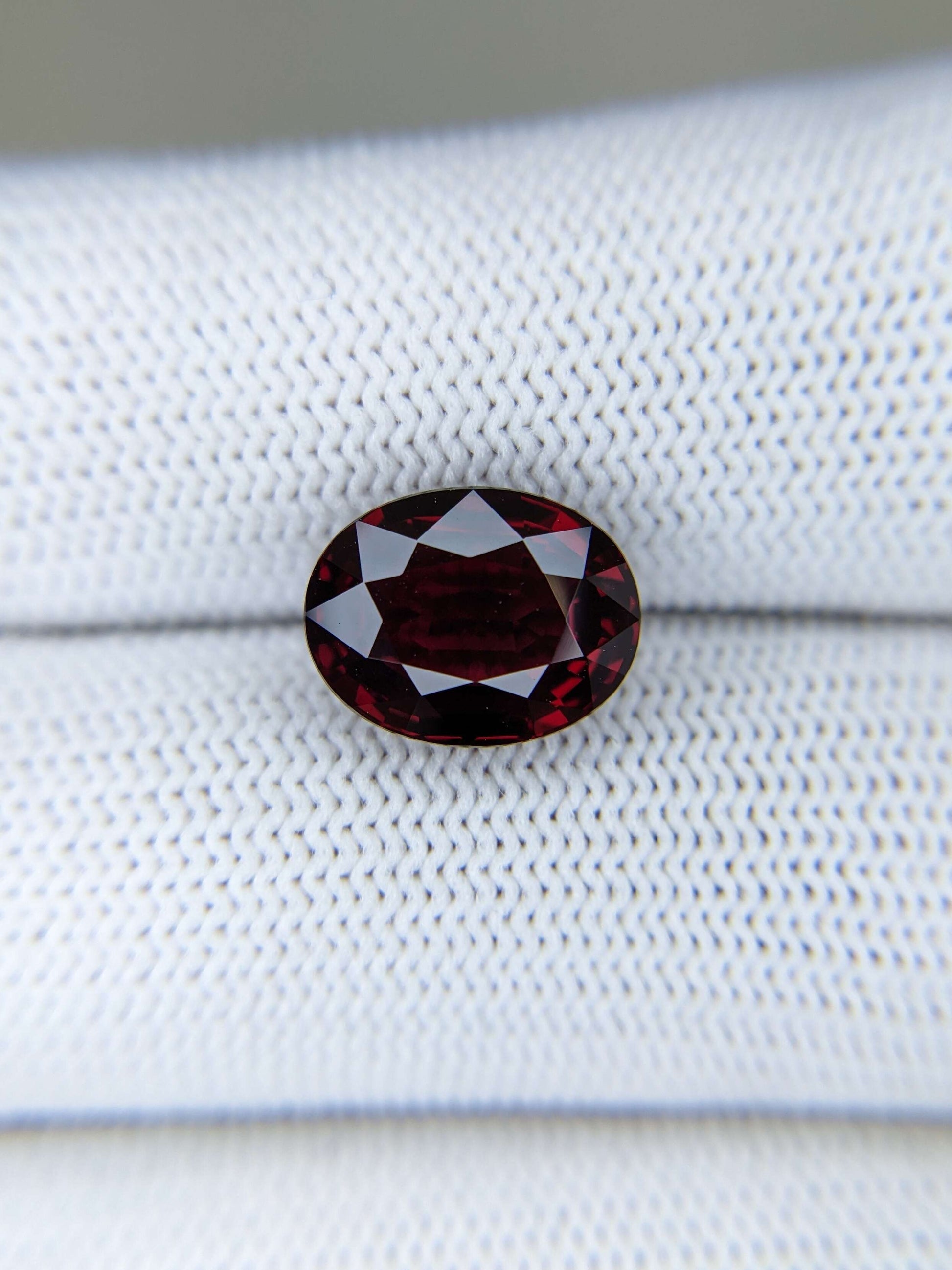 Red gemstone on a fabric white surface