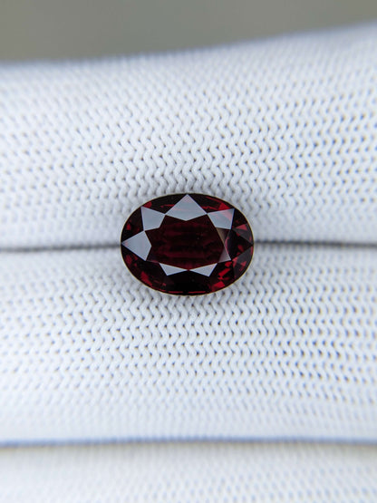 Red gemstone on a fabric white surface