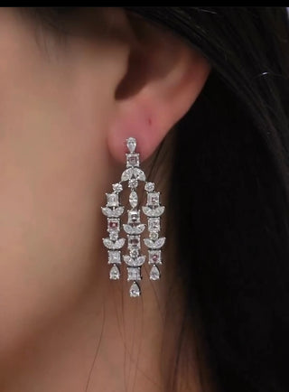 Three strand chandelier earrings containing Asscher Cut and Marquise diamonds along with pear-shaped diamonds on a model