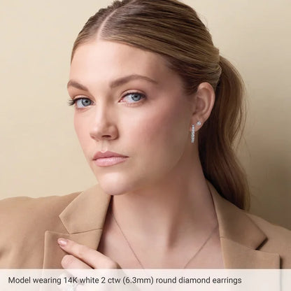 Woman wearing 14K white gold diamond earrings against a beige background