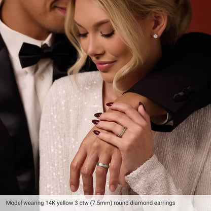 Woman wearing 14K yellow gold round diamond earrings with a man in formal attire.
