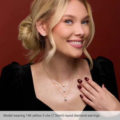Woman wearing 14K yellow gold diamond earrings and necklace against a red background