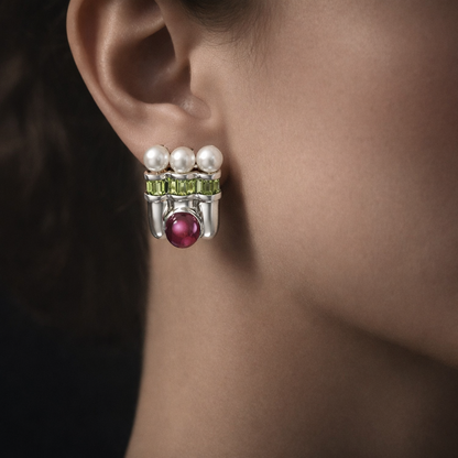 Close-up of an earring with pearls and gemstones on a person's ear.