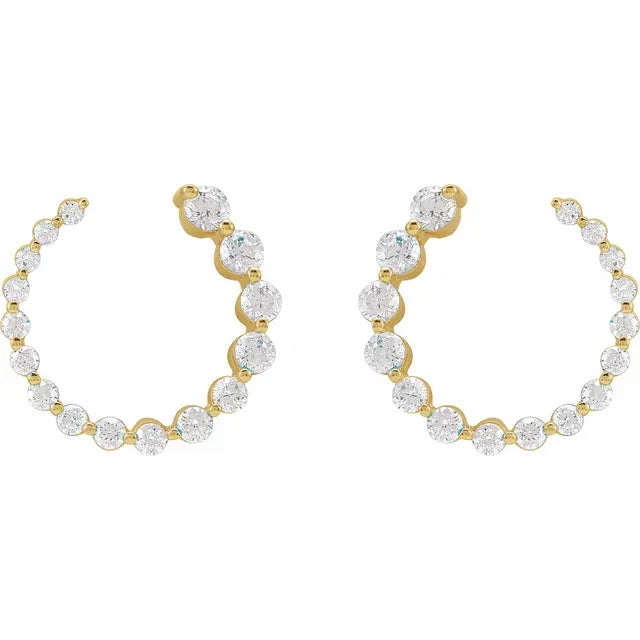 Gold stud earrings with clear gemstones on a white background