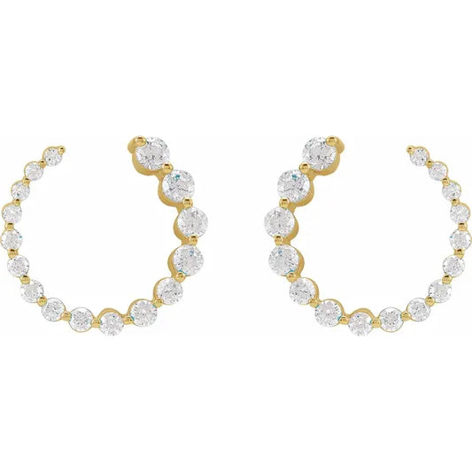 Gold stud earrings with clear gemstones on a white background