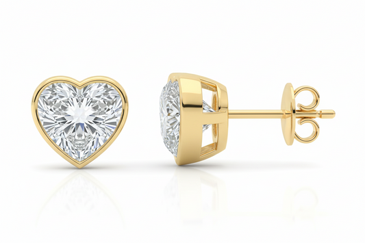 Gold heart-shaped diamond earrings on a white background
