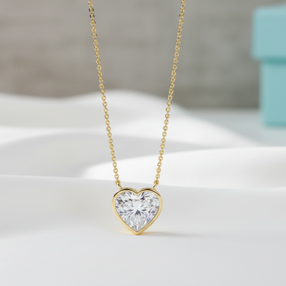 Gold heart-shaped diamond necklace on a light background