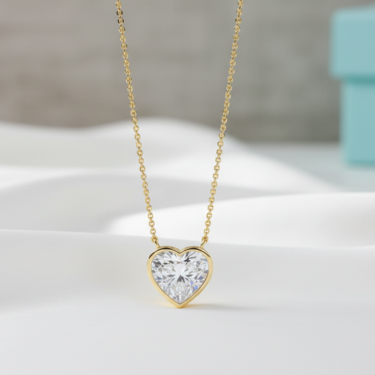 Gold heart-shaped diamond necklace on a light background