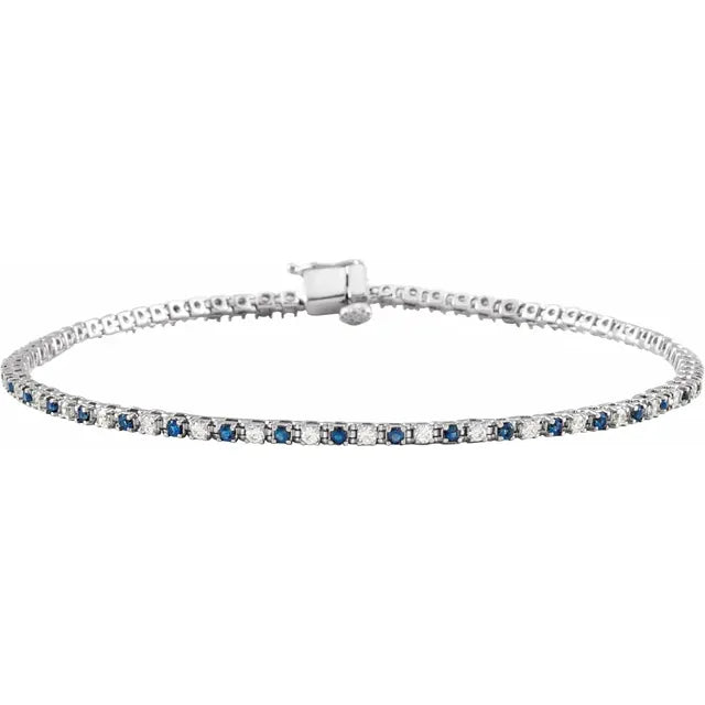 white gold tennis bracelet with blue sapphire and diamond stones on a white background