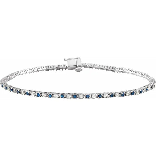 white gold tennis bracelet with blue sapphire and diamond stones on a white background