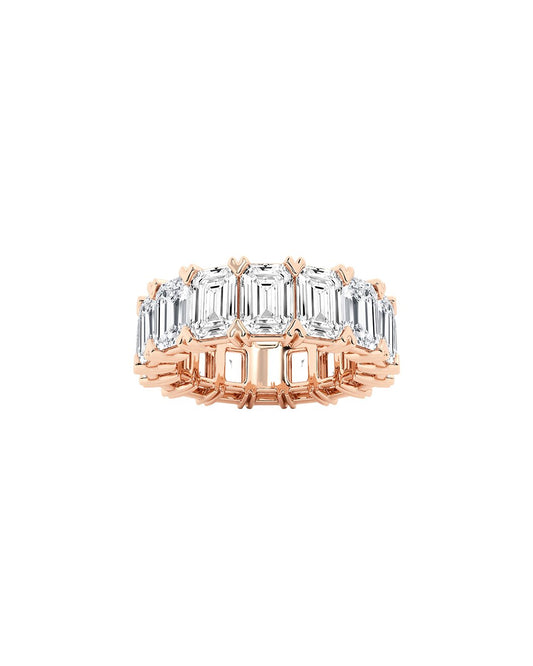Rose gold ring with emerald-cut diamonds on a white background