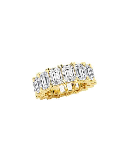 Gold ring with emerald-cut diamonds on a white background