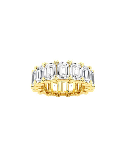 Gold ring with emerald-cut diamonds on a white background