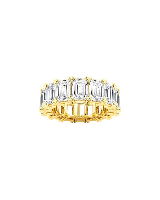Gold ring with emerald-cut diamonds on a white background