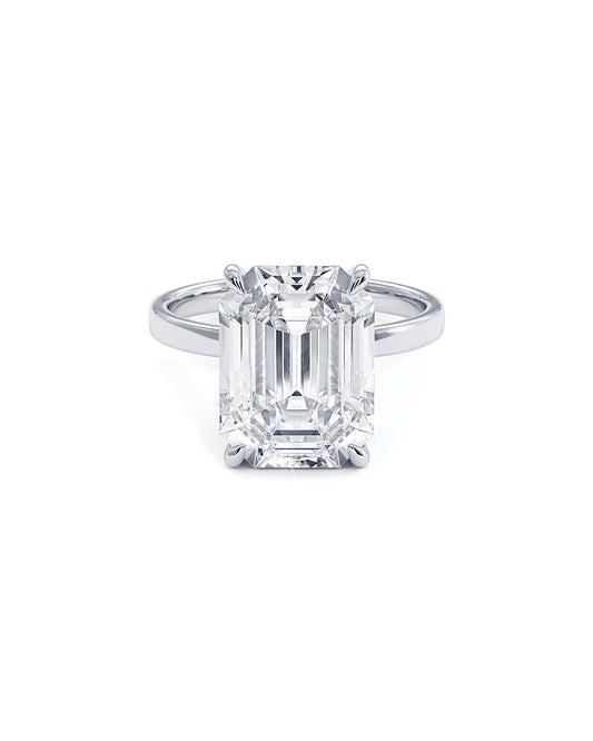 Diamond ring with emerald-cut stone on a white background