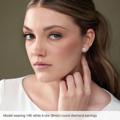 Woman wearing 14K white gold round diamond earrings with a neutral background