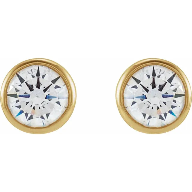 Gold bezel circular earrings with a central gemstone on a white background