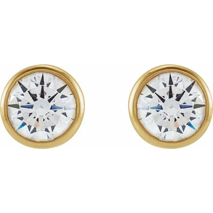 Gold bezel circular earrings with a central gemstone on a white background