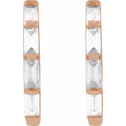 Pair of earrings with rose gold and clear diamonds design on a white background