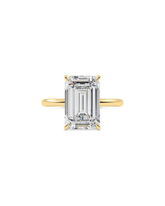 Gold ring with a large emerald-cut diamond on a white background