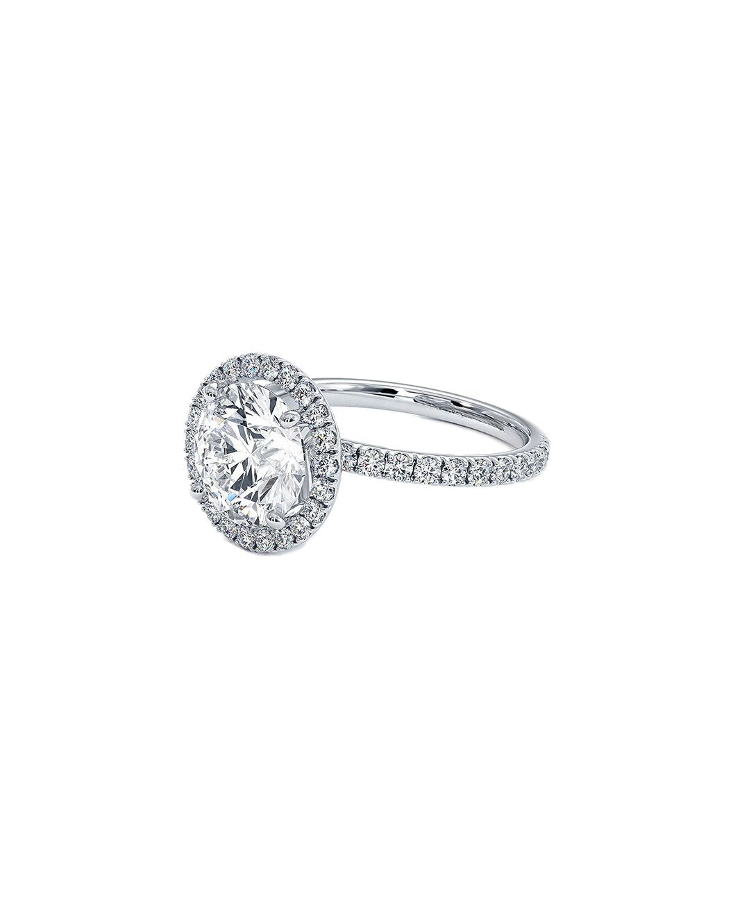 Diamond ring with a halo and sidestone setting on a white background