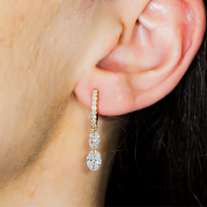 Close-up of an ear wearing a diamond earring with a blurred background