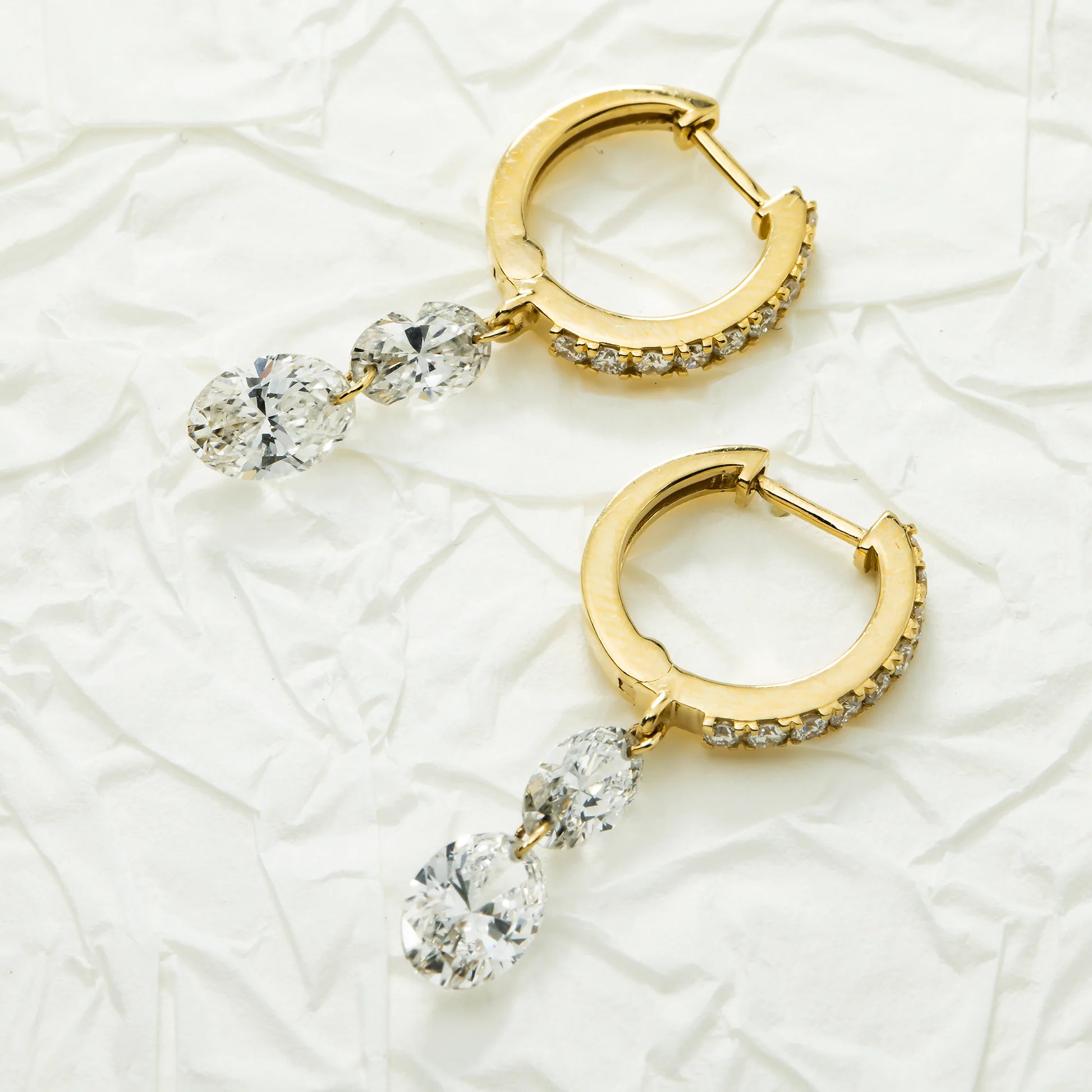 Huggie Drop diamond earrings on a white background