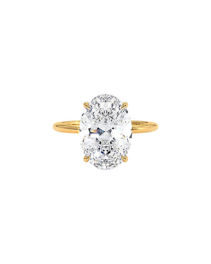 Yellow gold ring with a large oval diamond on a white background