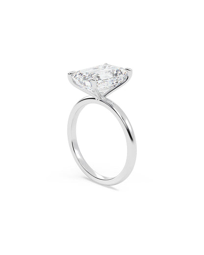 Diamond ring with an emerald diamond on a white background