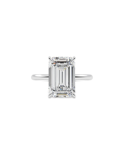 Diamond ring with emerald-cut stone on a white background