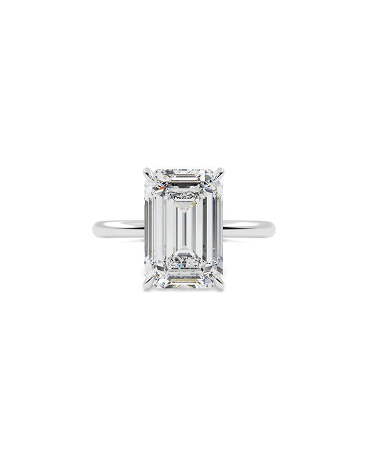 Diamond ring with emerald-cut stone on a white background