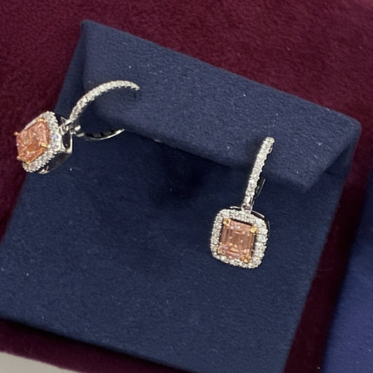 Diamond earrings on a blue stand with a purple background