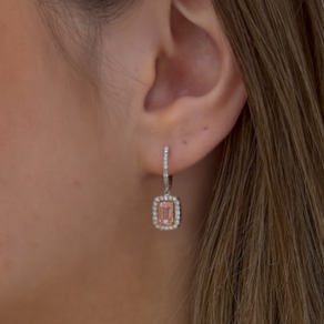 Close-up of an earring worn by a person with brown hair.