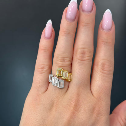 Hand wearing two diamond rings with a dark background