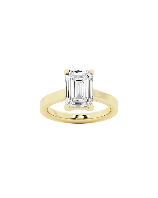 Gold ring with an emerald-cut diamond on a white background