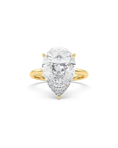 Yellow gold ring with a pear-shaped diamond on a white background