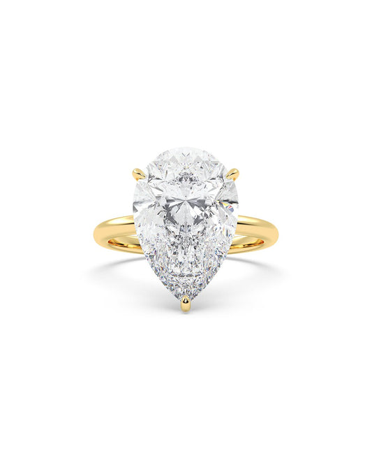 Yellow gold ring with a pear-shaped diamond on a white background