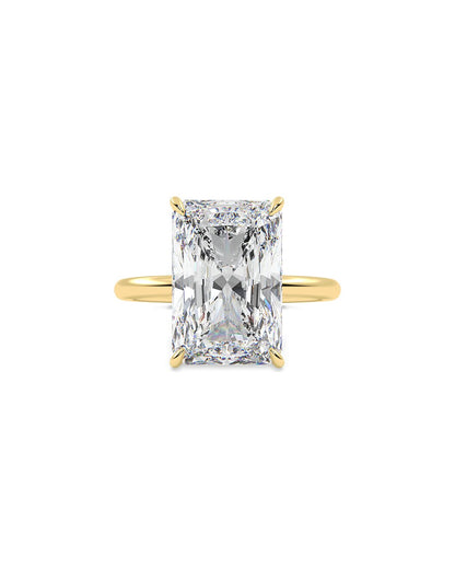 Gold ring with a large radiant diamond on a white background