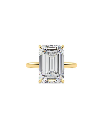 Yellow Gold ring with a large emerald-cut diamond on a white background