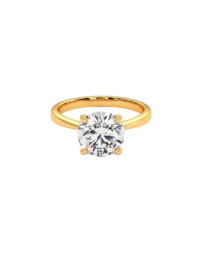 Gold ring with a clear round cut diamond on a white background