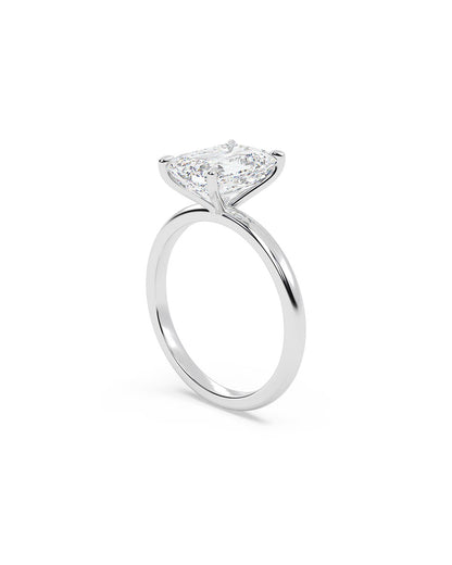 Diamond ring with an emerald-shaped center stone on a white background