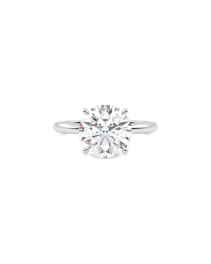 Round cut diamond ring on a white background