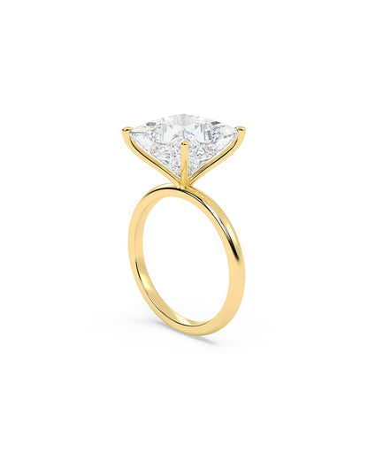 Yellow gold ring with a large princess cut diamond on a white background