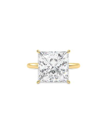 yellow gold ring with a large princess cut diamond on a white background